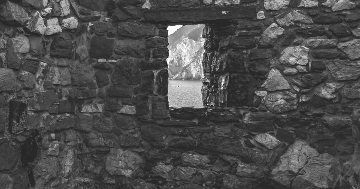 Stone wall with a single window opening onto a mountain view