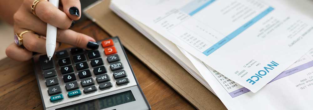 Business executive with a calculator and bills considering corporate bankruptcy or commercial insolvency